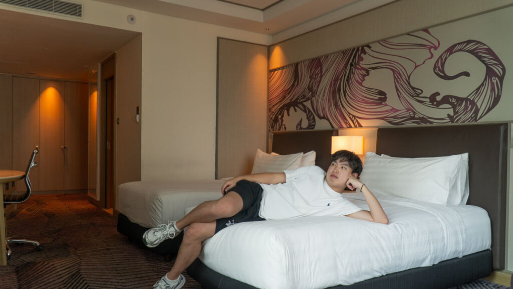Wayne lying on a bed in his room in Amari Hotel - JB hotels near attractions