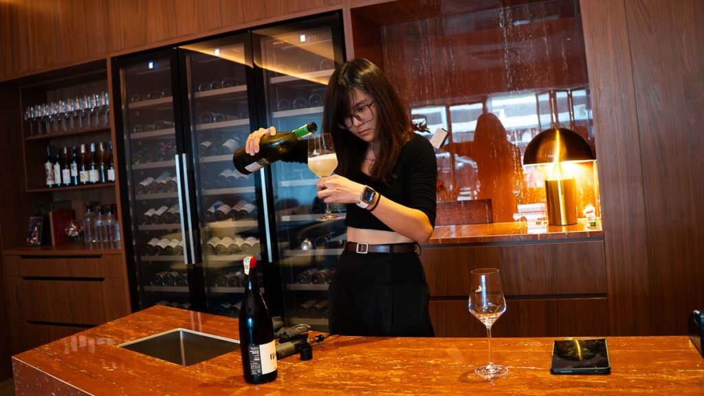 Person pouring moscato wine into a wine glass