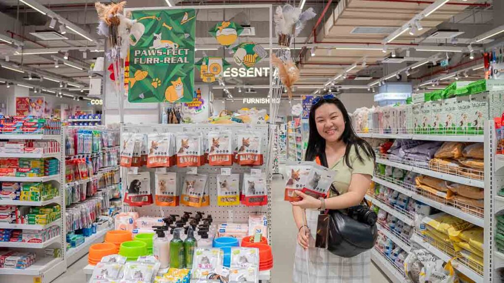 Person holding up pet treats and toys in the pet section of MR D.I.Y.