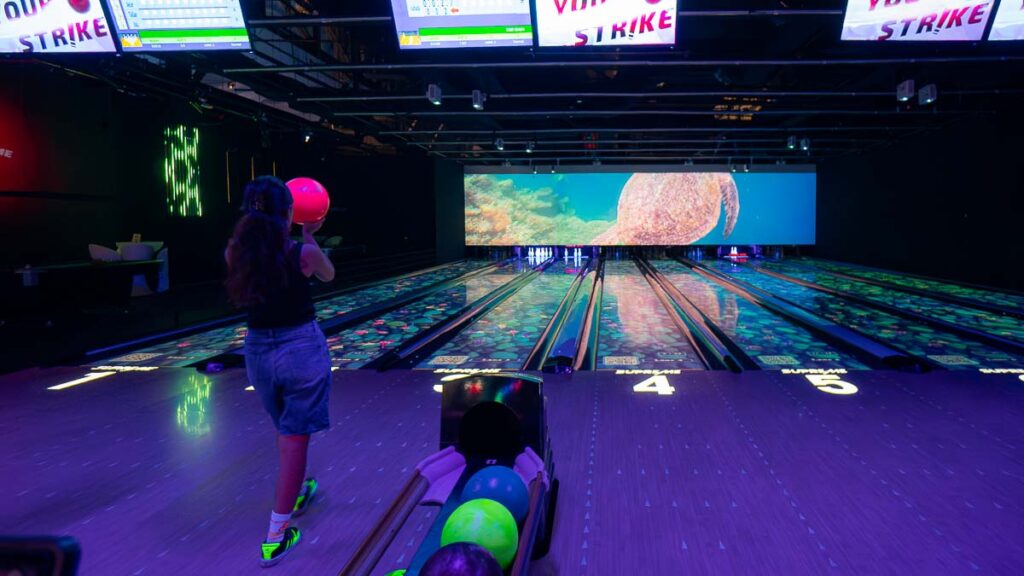 Person bowling in the dark at Supreme Cosmic Bowl