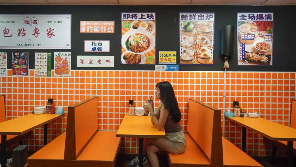 girl sitting in a restaurant holding  drink 