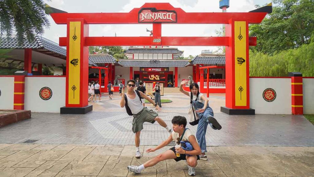 3 people posing in front of Ninjago logo - Things to do in Legoland Malaysia