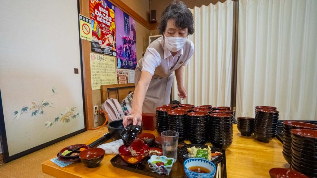 Waitress serving wanko Soba at yamanekoken Iwate japan - Tohoku Summer itinerary