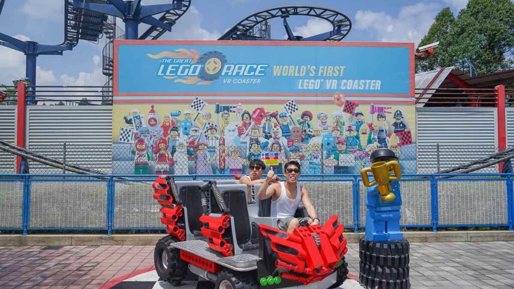2 people posing in front of rollercoaster - Things to do in Legoland Malaysia