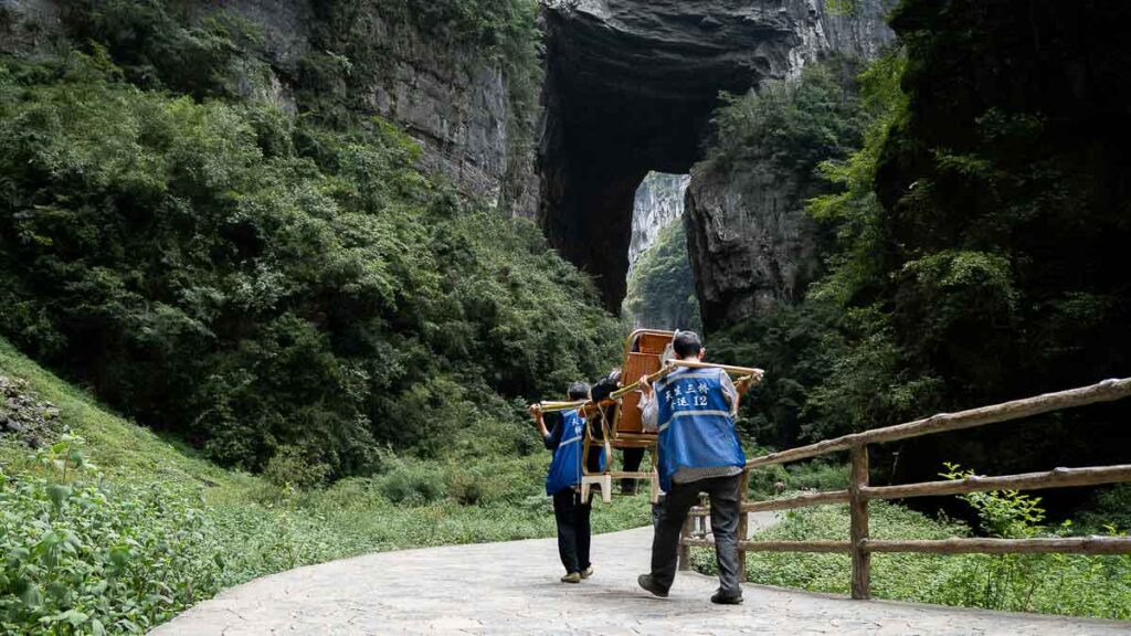 Porters carrying a person through the Three Natural Bridges Trail