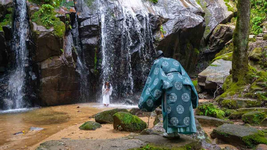 Girl standing under the waterfall for Takigyo ritual in Miyazu - Kyoto by the Sea