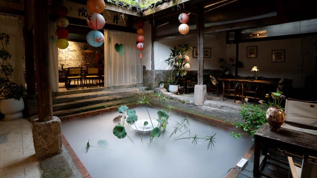 Interior of a teahouse at Jingangbei Ancient Village, featuring a plant in the middle of misty fog surrounding it