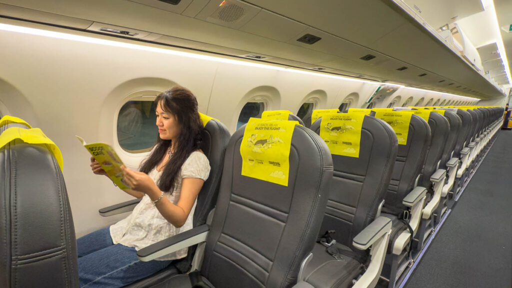 Girl reading on the new Scoot Embraer plane - Getting to Davao
