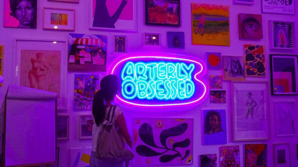 Girl looking at paintings on a wall - Singapore art scene