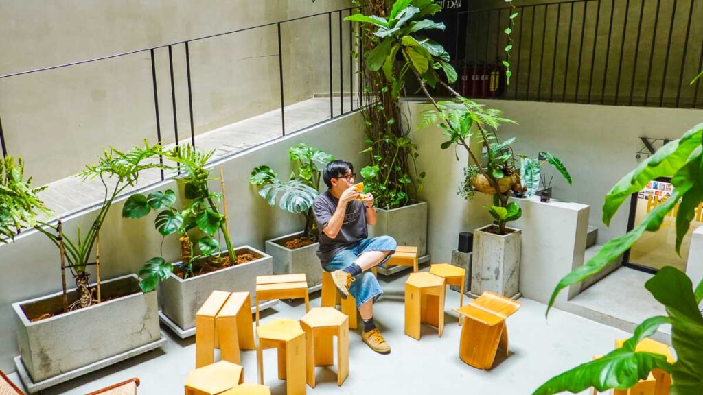 Boy drinking coffee in nature cafe - Best cafes in Vietnam