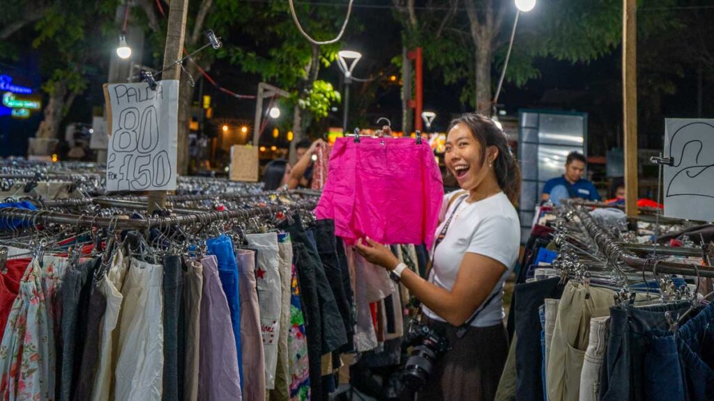Girl holding up clothes from Roxas Night Market - Davao attractions