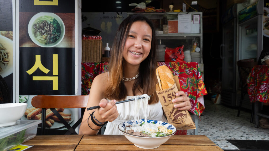 girl eating noodle and banh mi - ho chi minh city budget guide