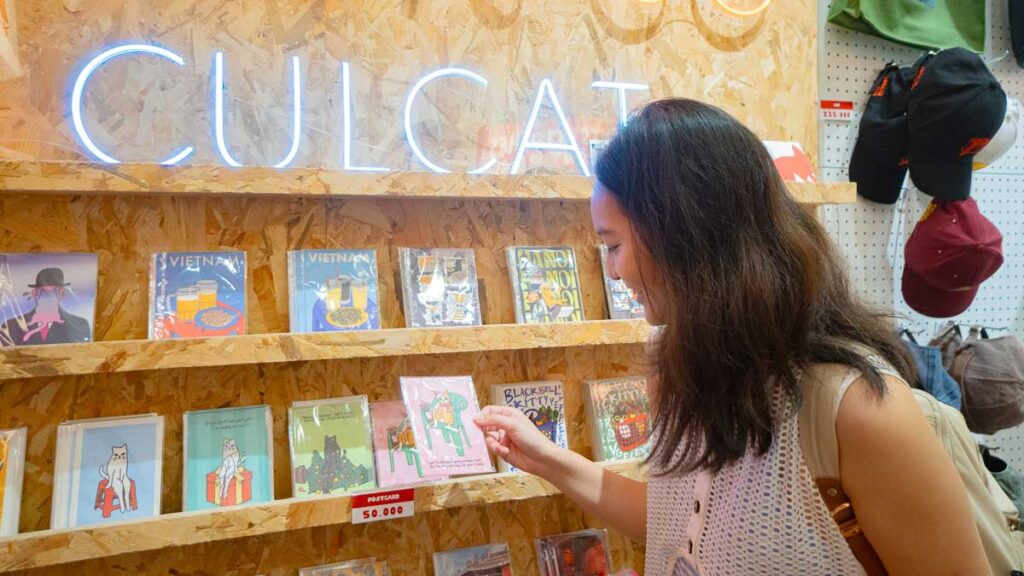 Girl looking at postcards- Ho Chi Minh City Budget Itinerary