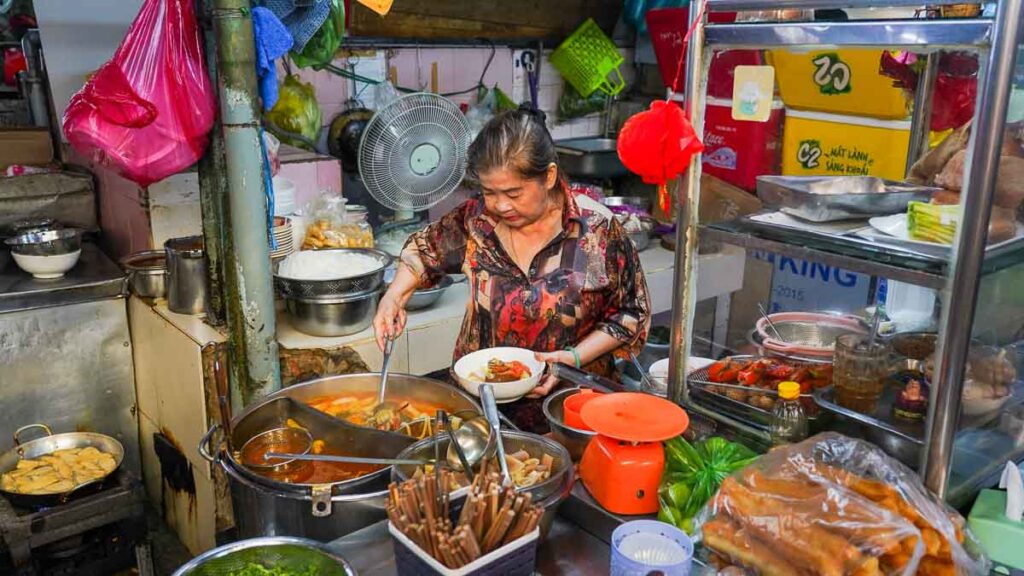 Lady cooking in market - Ho Chi Minh City Budget Itinerary