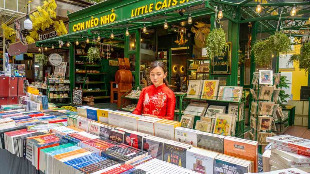 Girl in ao dai looking at books - Ho Chi Minh City Things to Do