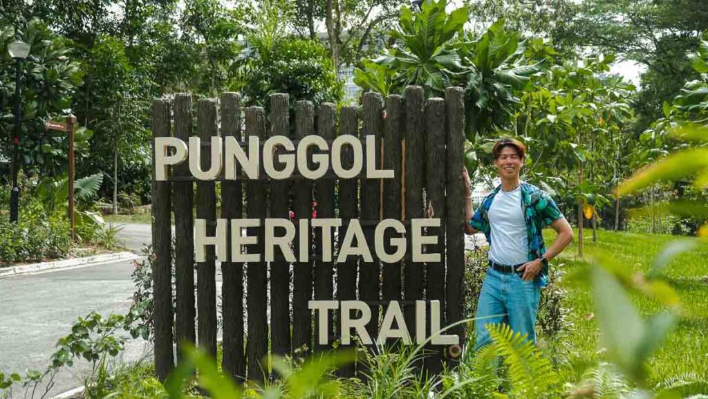 Man standing in front of signboard - things to do in punggol