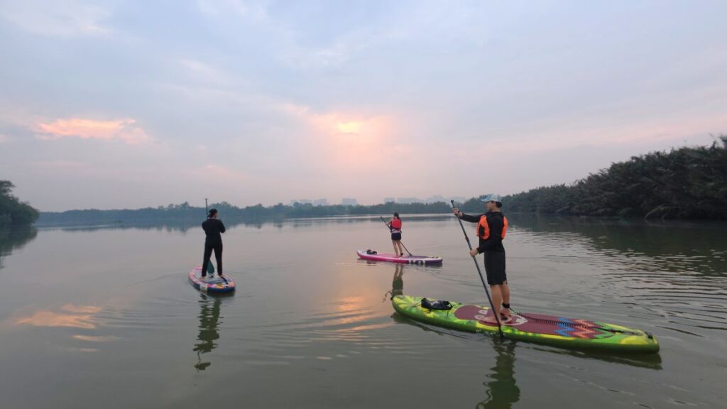 Tourists paddleboarding along Saigon River - Things to Do in Saigon