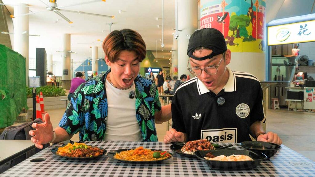 two men looking at food at hawker centre - things to do in punggol