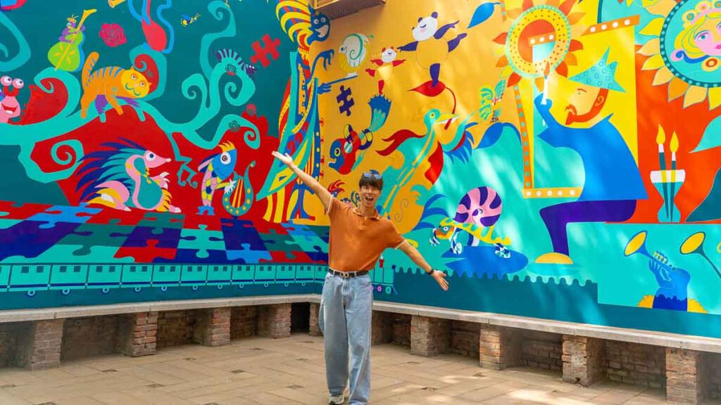 Man in front of Colourful Mural - Beijing Itinerary