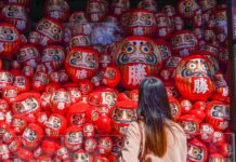 7 Lesser-known Things to do in Osaka that Most Tourists Don’t Know Girl looking at Darumas - Lesser-known things to do in Osaka