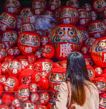 7 Lesser-known Things to do in Osaka that Most Tourists Don’t Know Girl looking at Darumas - Lesser-known things to do in Osaka