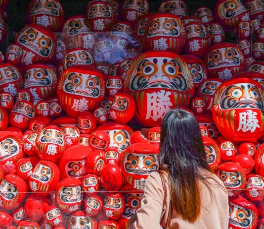 7 Lesser-known Things to do in Osaka that Most Tourists Don’t Know Girl looking at Darumas - Lesser-known things to do in Osaka
