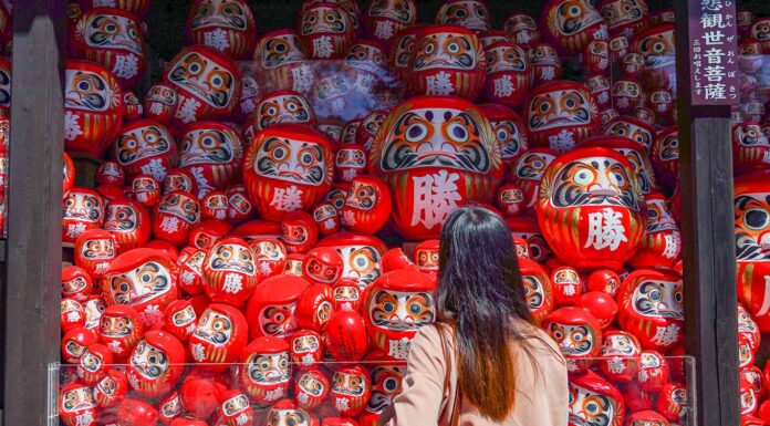 7 Lesser-known Things to do in Osaka that Most Tourists Don’t Know Girl looking at Darumas - Lesser-known things to do in Osaka