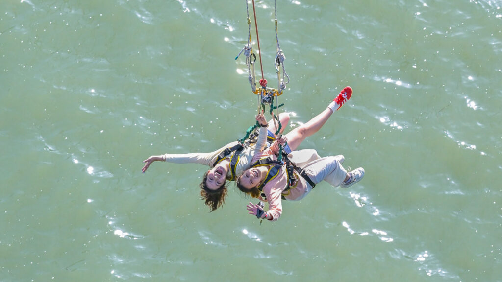 Girls doing bridge swing over water - Lesser-known things to do in Osaka
