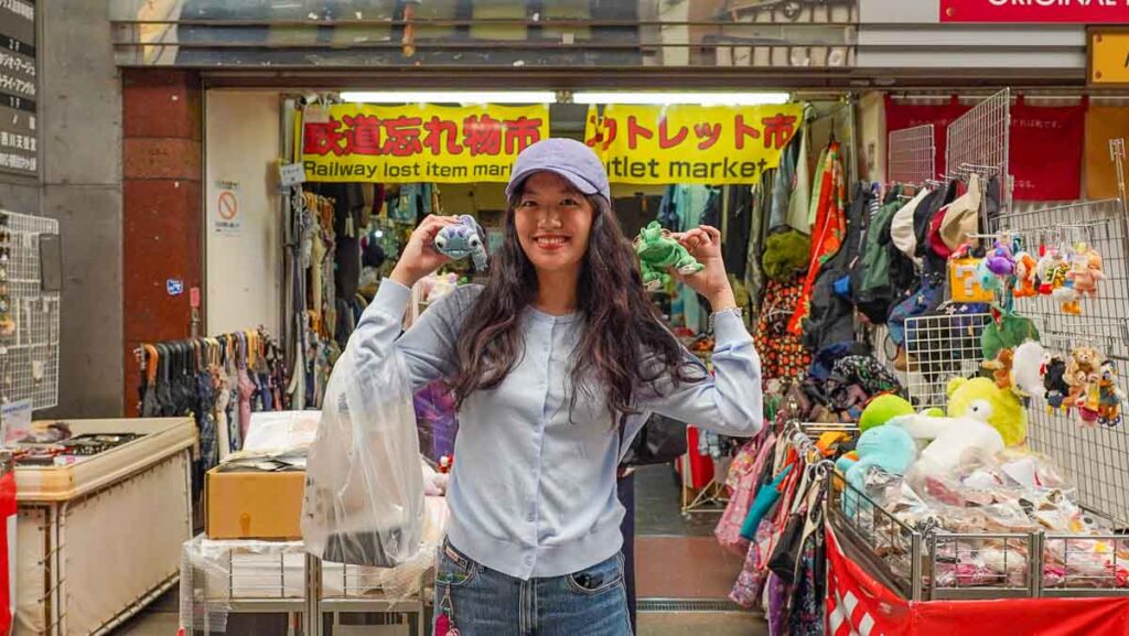 Girl holding up items - Non-touristy Osaka