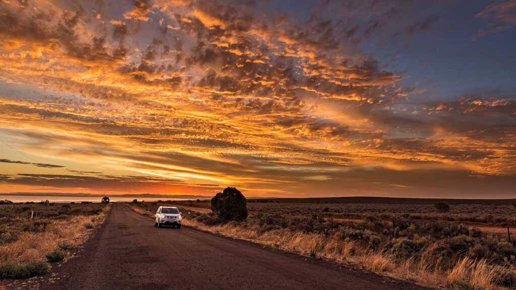 Car driving in front of a sunset in Whyalla  - South Australia Road Trip