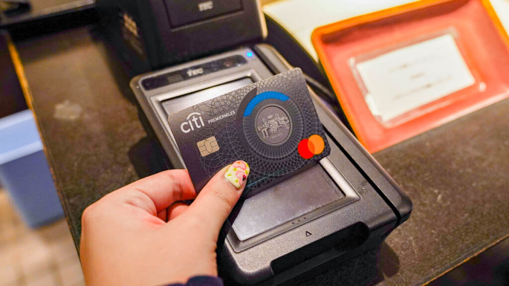 Girl tapping credit card - Lesser-known things to do in Osaka