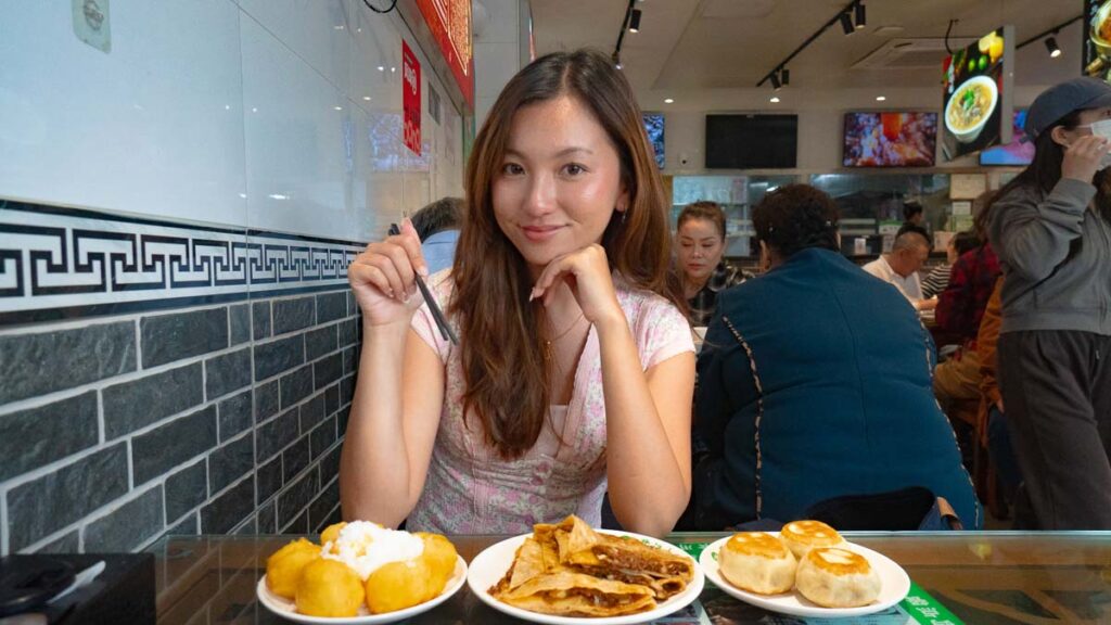 Girl holding food and posing for camera - Beijing Itinerary