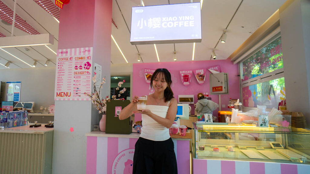 Girl holding onto coffee drink in cafe - Beijing Itinerary