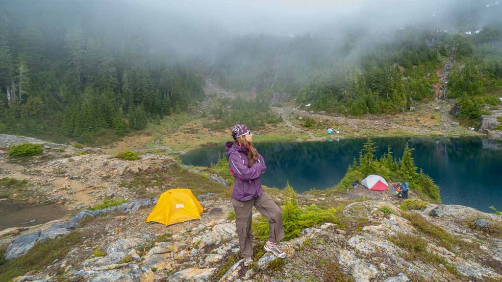 Girl standing in front of lake and trees - Vancouver places to visit