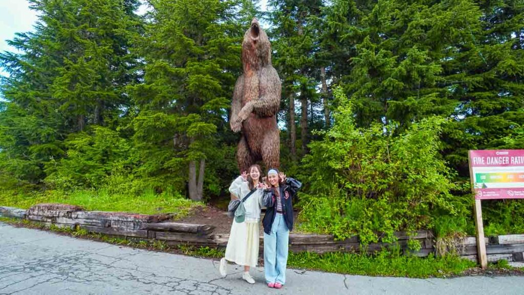 Girls posing in front of a bear statue - Vancouver day trips
