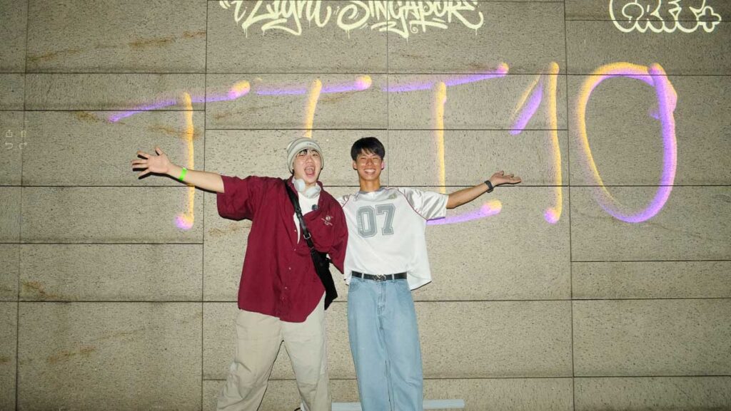 Two men in front of digital Graffiti wall - Things to do in Singapore June